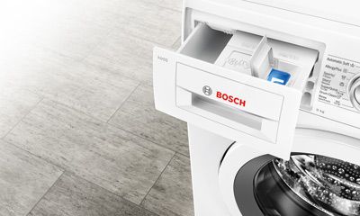 Dunkle Küche mit integrierten Siemens-Backöfen und beleuchteten Regalen.